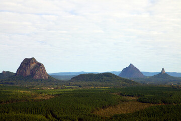 Fototapeta na wymiar Glass House Mountains, Sunshine Coast, Queensland, Australia showing blue sky, mountains, paddocks, farming land and forests