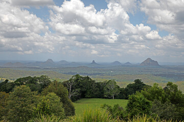 Fototapeta premium Glass House Mountains, Sunshine Coast, Queensland, Australia showing blue sky, mountains, paddocks, farming land and forests