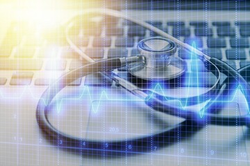 Classic metal medical stethoscope on the computer keyboard