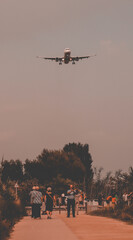 Fototapeta na wymiar Aereo mentre atterra all'aeroporto El-Prat di Barcellona, passando sopra al parco.