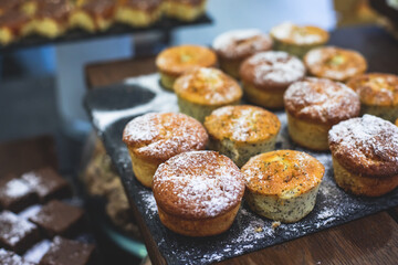 Decorated breakfast catering setting at the hotel, with variety of dishes: cereal, corn flakes, vegetables, toast, pancakes, pastry, cupcakes and other food