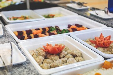 Decorated breakfast catering setting at the hotel, with variety of dishes: cereal, corn flakes, vegetables, toast, pancakes, pastry, cupcakes and other food