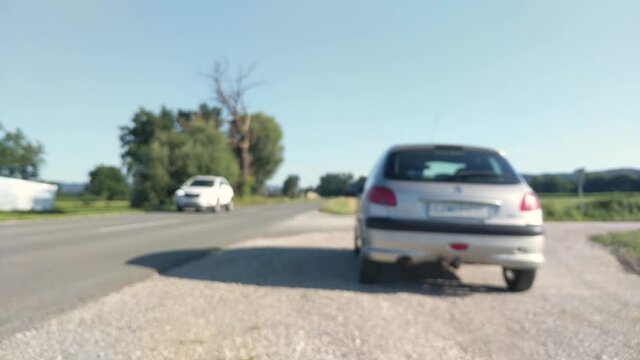 Blurred video of a broken down car by the side of the road 