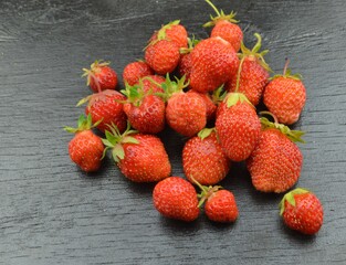 
fresh strawberries lie on a black wooden background
