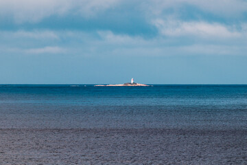 Obraz premium beautiful Tasmanian beach landscape with he Iron Pot island and lighthouse in the distance