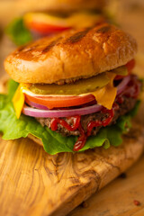 Hamburger on a wooden background with french fries close-up, fast food