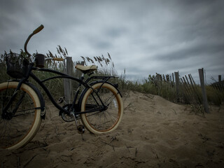 filtered image of a vintage bicycle and sand dunes on the beach
