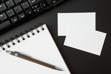Notebooks , pen , business cards and Keyboard computer  on black background