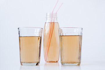 Two glasses and a bottle with Apple juice tubes on a white background