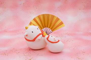 牛の土鈴の粘土人形　立体　ピンクの背景に金扇子