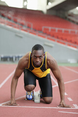 Male runner crouching on starting line