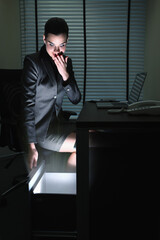 Businesswoman looking into a glowing drawer