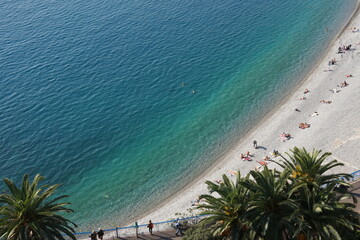 Aerial view of beach in Nice France with turquoise water palm trees and blue sky. Photo for art decoration and blog story.