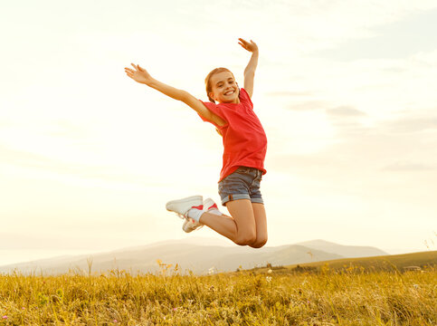 Happy girl jumping in field.