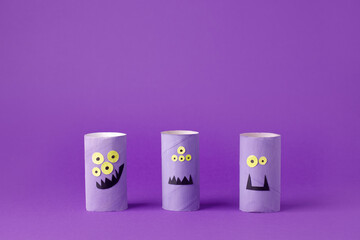 Halloween toy collection of monsters on purple for Halloween concept background. Paper crafts, easy DIY. Handcraft creative idea from toilet tube, recycle concept, copy space, flyer, banner