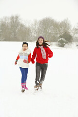 Fototapeta na wymiar Two girls having fun in the snow