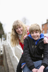 Boy and girl smiling at the camera outdoors