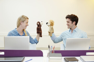 Business people playing with hand puppets