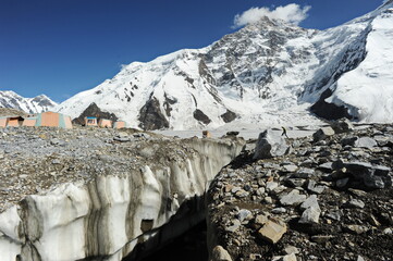 The fault of the earth and ice blocks with fragments of stones against the background of the Khan Tengri mountain