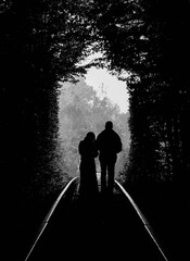 Silhouette of a couple, walking into the distance along the tunnel.