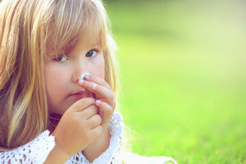Girl smelling a small daisy