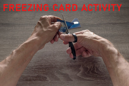male hands with scissors cut the payment blue master card. concept of liquidation, destruction of deactivation, decommissioning with the inscription freezing card activity.