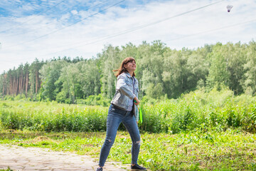 Woman playing badminton outdoors, summer time, green.