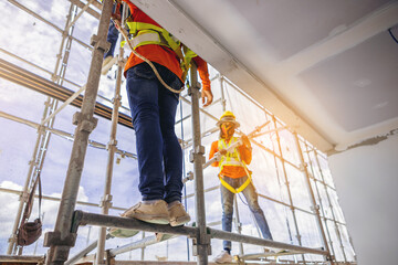 Construction workers in safety uniform install reinforced steel scaffolding at outdoor construction...