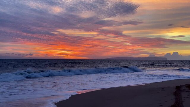Stunning orange sunset sky over Niihau island seen from Kauai's Kekaha beach park