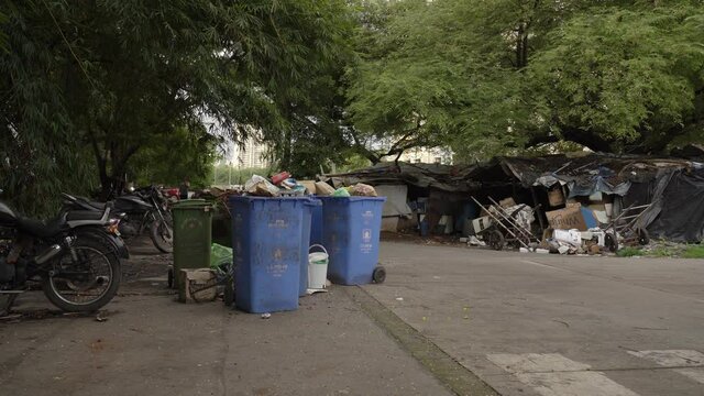 Empty Mumbai slum street during corona covid lockdown curfew with garbage bins vehicles passing