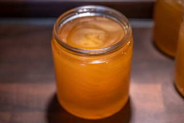 Golden yellow honey in glass jar on wooden board Closeup Copy space comp frame empty textspace