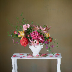 bouquet of summer flowers in vase on vintage white wooden shelf