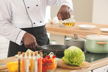 Male African-American chef cooking in kitchen