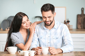Happy young couple drinking tea at home