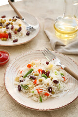 Plate with tasty rice, beans and vegetables on table
