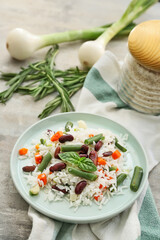 Plate with tasty rice, beans and vegetables on table