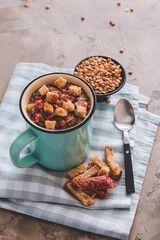 Cup of tasty lentils soup on grunge background