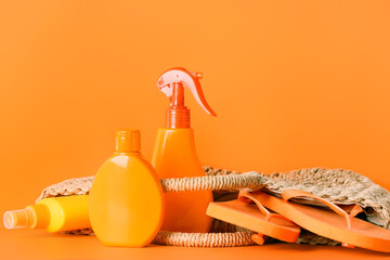 Beach accessories with sunscreen cream on color background