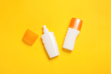 Bottles of sunscreen on color background
