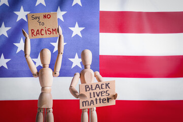 Mannequins with text BLACK LIVES MATTER and SAY NO TO RACISM on posters near flag of USA