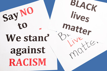 Different placards on color background. Stop racism