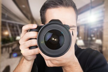 Beautiful male photographer with a camera on background