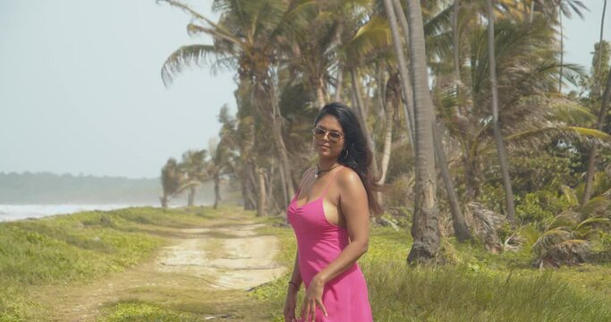 Sexy east indian model plays with her hair in the wind at this Caribbean coastline beach destination