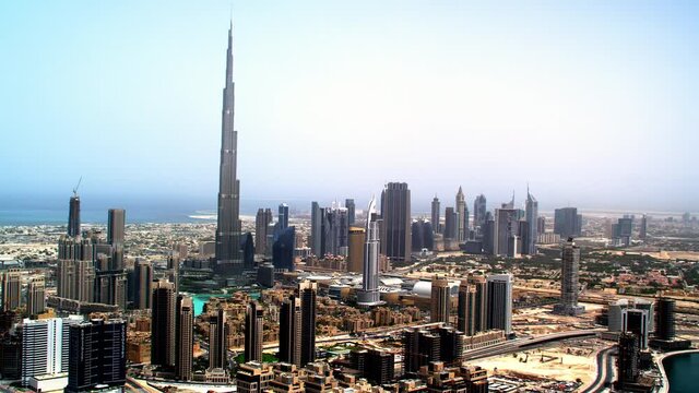 An astounding aerial view of Burj Khalifa and Downtown with a beautiful Dubai skyline close to it's the busiest highway on traffic Shaikh Zayed road.