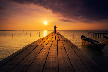 Lonely person standing on a pontoon meditating - obrazy, fototapety, plakaty