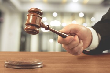 A man lawyer holds a wooden gavel