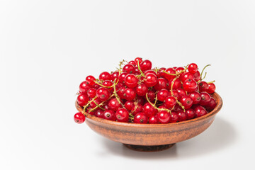 Red currant in clay bowl on white background. Fruit bowl. Delicious food. Copy space. High quality close up photo