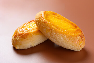 side view two pieces egg yolk flavor bread on brown background