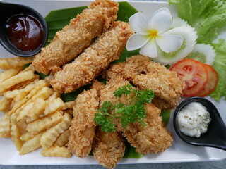 Set chicken, french fries and sauce dish decorated with white frangipani.