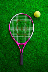 dual colour tennis racket and ball on resting on grass